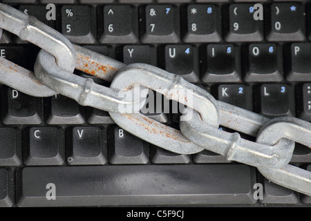 a laptop / computer keyboard locked with a thick heavy chain , conceptual image Stock Photo