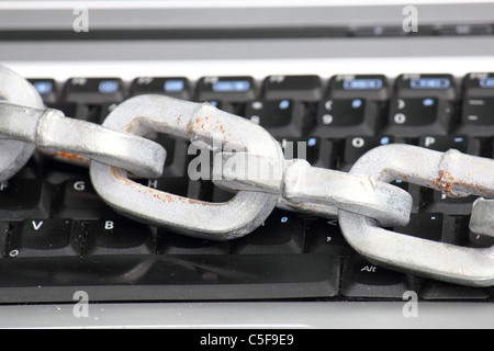a laptop / computer keyboard locked with a thick heavy chain , conceptual image Stock Photo