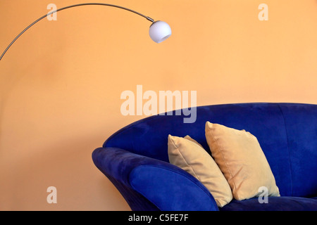 a blue sofa with reading lamp and yellow pillows and walls Stock Photo
