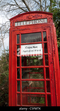 A sign on a red phone box saying 'Coins Not Accepted Here' in rural Gloucestershire, England UK Stock Photo