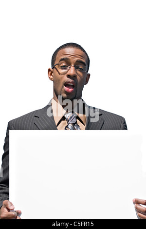 A young man holds up a blank white sign with copyspace. Stock Photo