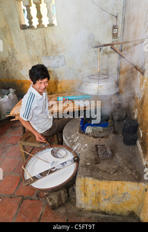 Viet Trinh Quang, 53, shows how he makes rice paper (for cooking) in the kitchen of his home, Tho Ha village, Vietnam Stock Photo