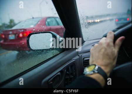 A first person point of view of driving on a freeway in the rain. Stock Photo