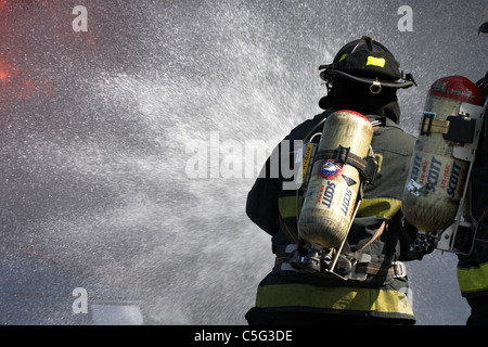 Two firefighters putting out a fire Stock Photo