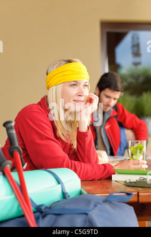 Tramping young couple backpack relax sitting by wooden table cottage Stock Photo