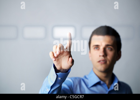 Image of young businessman pressing virtual button Stock Photo