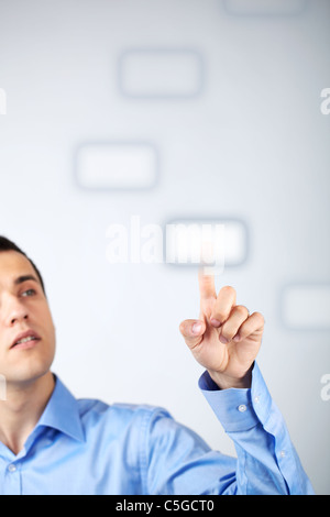 Close-up of young businessman pressing virtual button Stock Photo