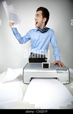 Portrait of nervous businessman at workplace with scanner on it Stock Photo