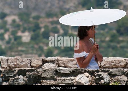 Young Woman Sheltering From The Sun With A Parasol On A Hot Day Stock Photo