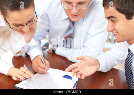 Three business people examining documents Stock Photo