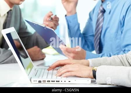 Female hands typing among working businesspeople Stock Photo