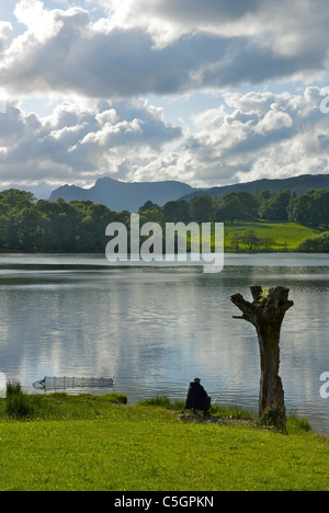 Angler on the shore of Loughrigg Tarn, Lake District National Park, Cumbria, England UK Stock Photo