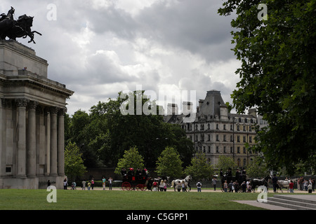 HYDE PARK CORNER, two carriages travel through the driveway of Wellington Arch at Hyde Park Corner with horse drawn carriages. Stock Photo