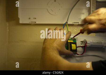 Qualified Electrician installing emergency lighting Stock Photo