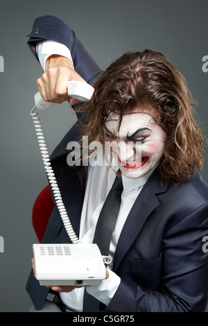 Portrait of furious businessman with theatrical makeup ringing off Stock Photo