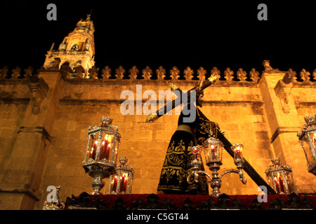 A throne displaying the Señor de los Reyes passes he Mosque-Cathedral during an Easter Holy Week procession in Cordoba, Spain Stock Photo