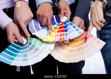Group of people hands pointing to color samples in palette pantone (selective focus) Stock Photo