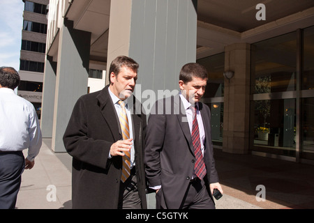 Two male corporate workers are deep in discussion as they enter their company. Stock Photo