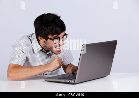 Nerd teenager working with his laptop with a funny face Stock Photo