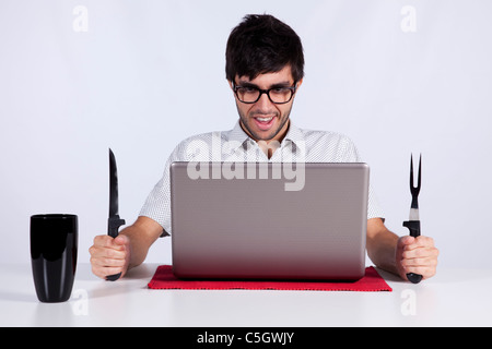 Young men at dinner table eating technology Stock Photo