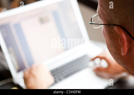 Man using a laptop indoors Stock Photo