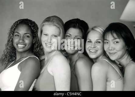 Ethnic mixture of five female friends smiling at camera in black and white Stock Photo