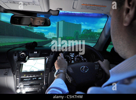 A visiting reporter sits behind the wheel of a driving simulator at Toyotas Higashi-Fuji Technical Center. Stock Photo