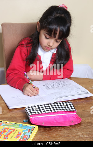 A 9 year old girl doing her homework. Stock Photo