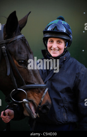 A female jockey with a racehorse at a stable in Gloucestershire UK Stock Photo