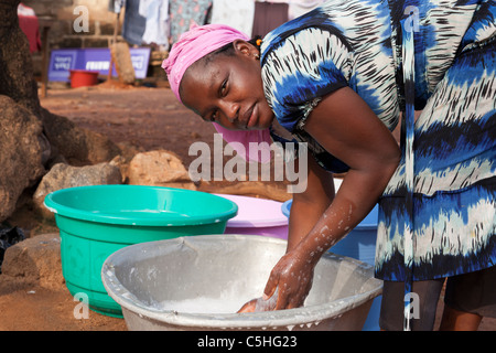 Portrait of an African woman washing clothes by hand in buckets. Accra, Ghana Stock Photo
