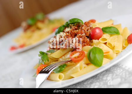 Rigatoni pasta with a tomato beef sauce on the oak table Stock Photo