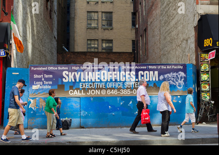 Pedestrians pass a banner advertising office space for rent in Lower Manhattan in New York Stock Photo