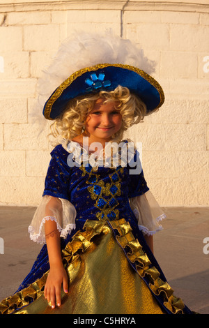 8-9 year old girl in crinoline. Small smiling girl in royal costume with a big hat. Stock Photo