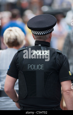 Police officers wearing bullet proof vests stand beside PSNI armoured ...