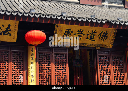 Lattice-work, elaborately-tiled roof, red lantern and inscribed motto above the entrance to the jade Buddha pavillion, Jade Stock Photo