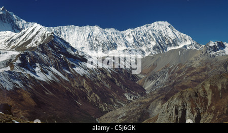 The long ridge of Tilicho Peak in the Annapurna Himal rises above the western end of the Manang Valley in north-central Nepal, Stock Photo