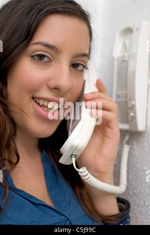 young woman using intercom system Stock Photo