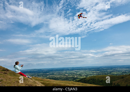 Girl flying kite at British Camp Iron Age hill fort in the Malvern Hills. Stock Photo