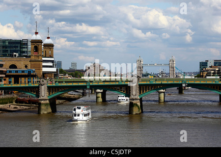 View along River Thames to Tower Bridge, cruise boat, Southwark Bridge and Cannon Street station (L) in foreground, London, England Stock Photo