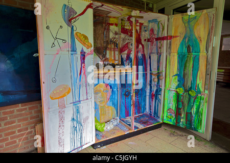 A three-part folding cabinet element, painted as a triptych, at the atelier of the E1 artists' group on Viktoriastraße in Grevenbroich, Germany, its inner panels showing abstract, comic-like motifs in blue, green and red tones. 23 July 2011. Stock Photo