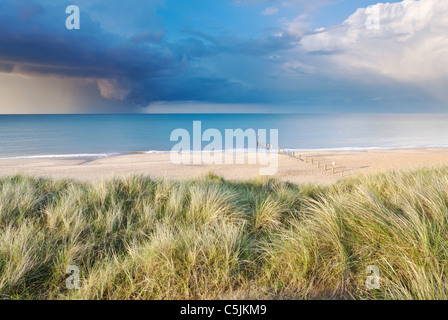 A summer storm out at sea captured here from the sand dunes at Horsey beach on the Norfolk Coast. Stock Photo