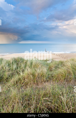 A summer storm out at sea captured here from the sand dunes at Horsey beach on the Norfolk Coast. Stock Photo