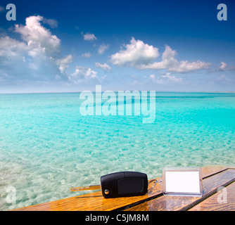 Car rental keys on wood table with blank paper in vacation Caribbean tropical beach Stock Photo