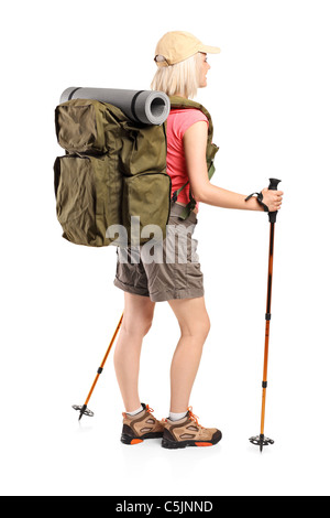 Full length portrait of a woman with backpack and hiking poles posing Stock Photo