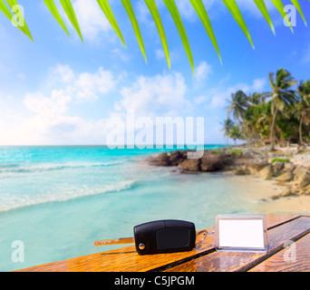 Car rental keys on wood table with blank paper in vacation Caribbean tropical beach Stock Photo