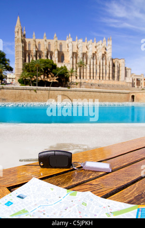 Car rental keys on wood table with city tourist map in Palma de Mallorca cathedral Stock Photo