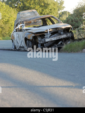 BURNED OUT STOLEN ABANDONED CAR DUMPED IN COUNTRY LANE,UK Stock Photo