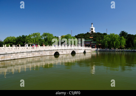 Marble bridge and white tower in a beautiful sunny day at Beihai Park. Beijing, China. Stock Photo