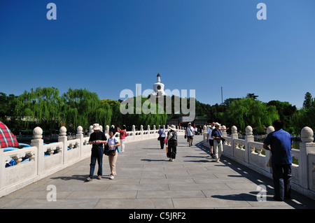 Tourists walking on the marble bridge in a beautiful sunny day at Beihai Park. Beijing, China. Stock Photo