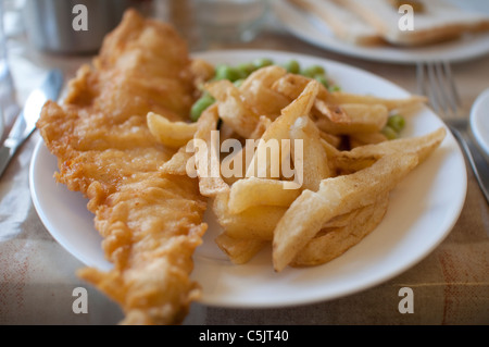 Fish and Chips served with mushy peas on a plate in England. Stock Photo